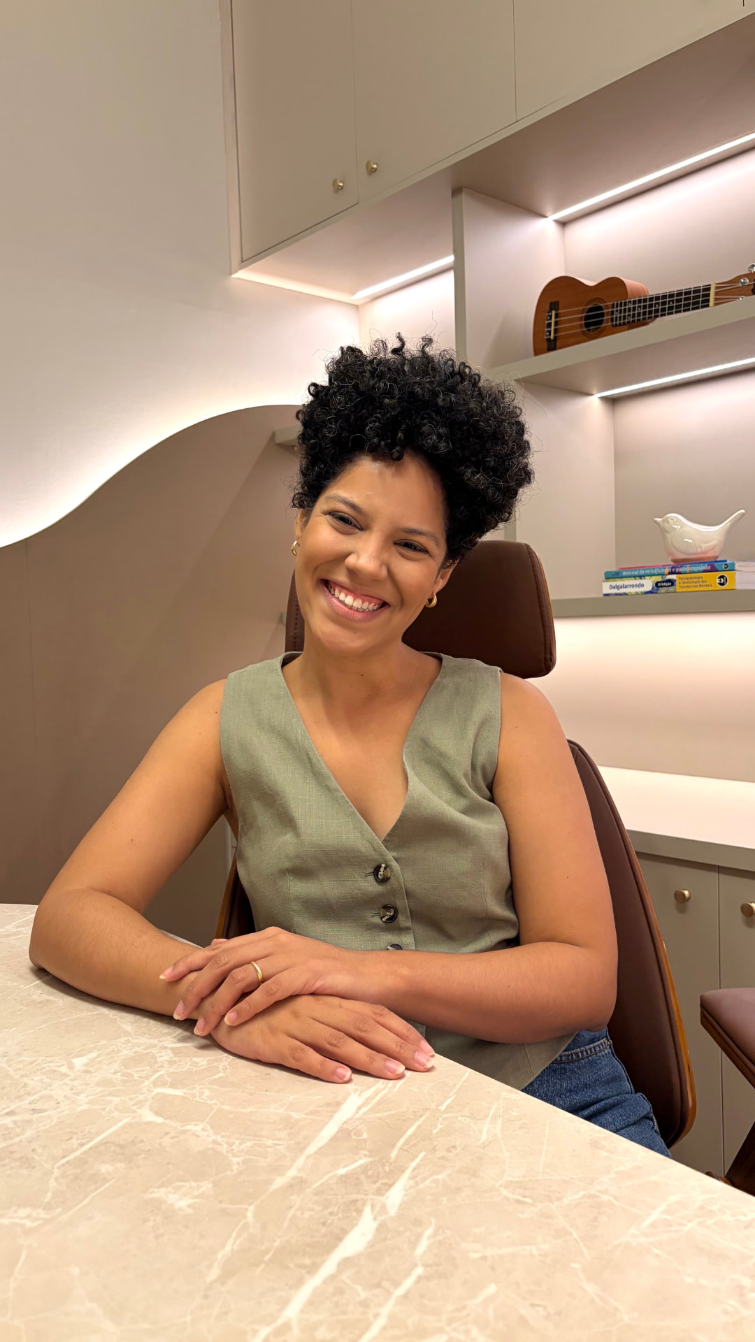 Mariana Neves, psicóloga, sorrindo em seu consultório